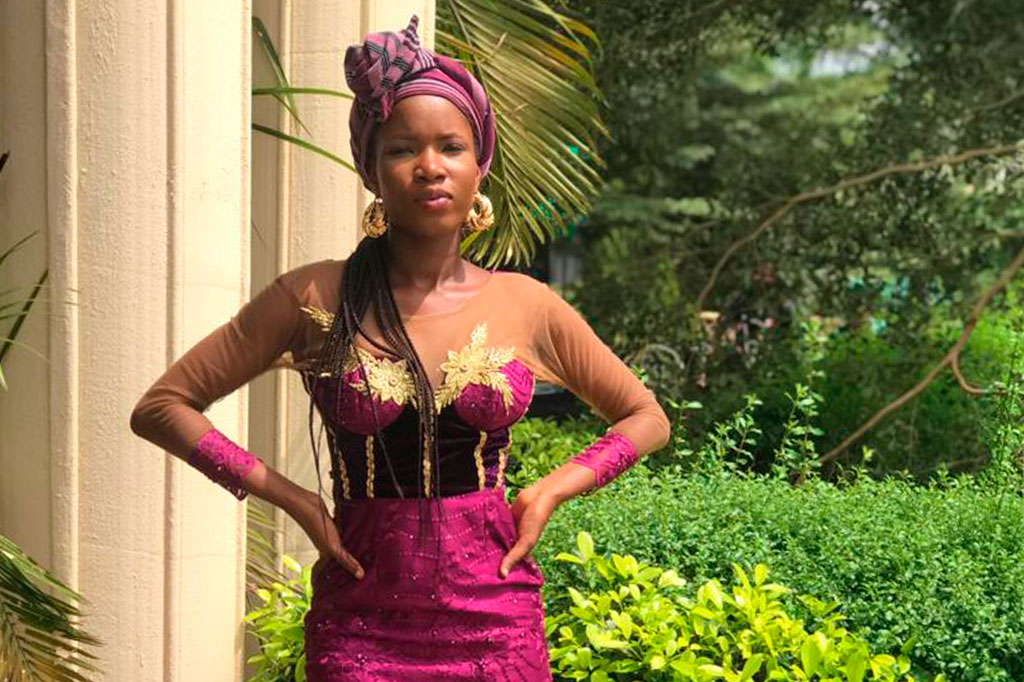 Storyteller Oluwaseun Famoofo dressed in a vivid purple dress and gele, ready to celebrate a friend's wedding as a bridesmaid.